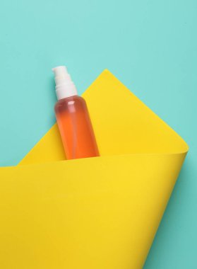 Sarı arka planda beyaz çerçeveli bir şişe losyon. Güzellik konsepti