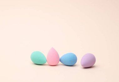 Makyaj süngerleri, bej arka planda kozmetik blenderler. Güzellik ürünleri.