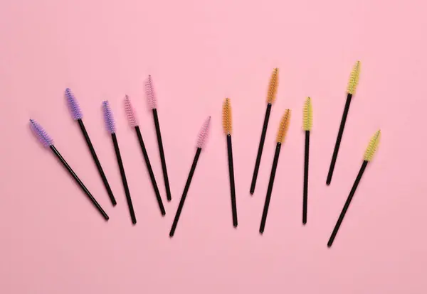 Set of brushes for combing eyelashes on pink background. Beauty concept
