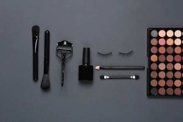 Set of beauty products, make-up accessories on a dark background. Flat lay