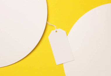 Beyaz daireli sarı arka planda boş fiyat etiketi. Yaratıcı düzen. Üst görünüm