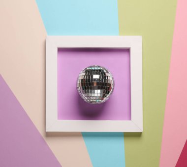 Beyaz kare çerçeveli disko topu renkli arkaplanda. Estetik asgari natürmort. Kavramsal fotoğraf. Modern sanat. Üst görünüm