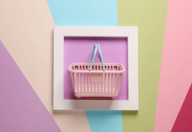 Renkli arka planda beyaz kare çerçeveli alışveriş sepeti. Estetik asgari natürmort. Kavramsal fotoğraf. Modern sanat. Üst görünüm