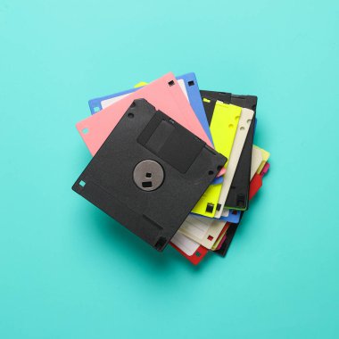 Mavi arka planda siyah ve renkli disketler. Bilgisayar teknolojisi 80 'ler.