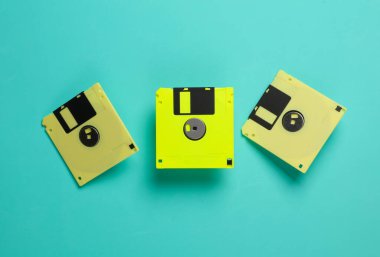 Mavi arka planda sarı disketler. Retro teknolojisi. Üst görünüm
