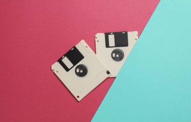 Mavi pembe arka planda beyaz disketler. Retro teknolojisi. Üst görünüm