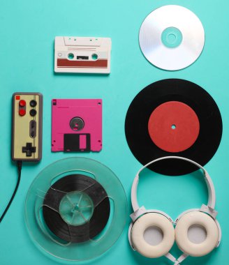 80 'lerden kalma geçmişe dönük özellikler. Kulaklıklar, joystick, manyetik kaset, ses kaseti, CD, vinil plak ve mavi arka planda disket. Üst Manzara. Düz yatıyordu