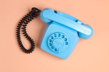 Pembe arka planda mavi bir döner telefon. Minimalizm. Üst görünüm