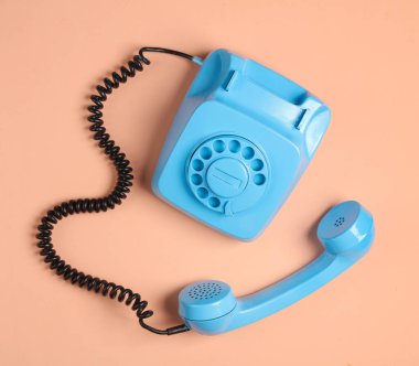 Pembe arka planda mavi bir döner telefon. Minimalizm. Üst görünüm