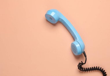 Pembe arkaplandaki Retro mavi telefon alıcısı