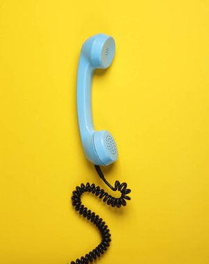 Sarı arkaplanda mavi telefon alıcısı