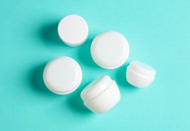 Mavi arka planda beyaz krema kavanozları. Model, tasarım şablonu. Üst görünüm