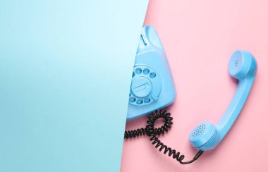 Pembe arka planda mavi renkli döner telefon. Üst Manzara. Minimalizm. Yaratıcı yerleşim