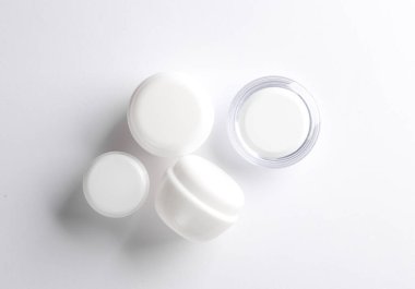 Beyaz arka planda beyaz krema kavanozları. Yaratıcı düzen. Tasarım şablonu. Modelleme. Asgari güzellik kavramı.