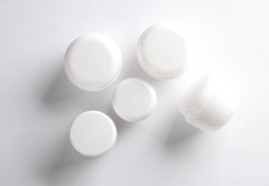 Beyaz arka planda beyaz krema kavanozları. Yaratıcı düzen. Tasarım şablonu. Modelleme. Asgari güzellik kavramı.