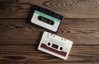 Ahşap arka planda 80 'lerin ses kasetleri. Müzik konsepti, klasik teknoloji. Üst görünüm.