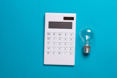 Mavi arka planda hesap makinesi ve ampul. Yaratıcı fikir