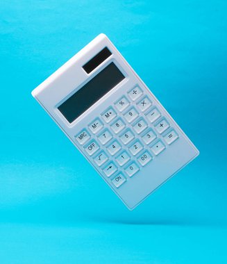 Beyaz hesap makinesi mavi arkaplanda gölgeli havada durur