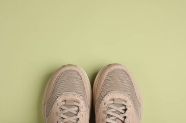 Yeşil arka planda bej koşu ayakkabıları. Üst görünüm