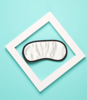 Beyaz kare çerçeveli uyku maskesi. Estetik asgari natürmort. Kavramsal fotoğraf. Üst görünüm