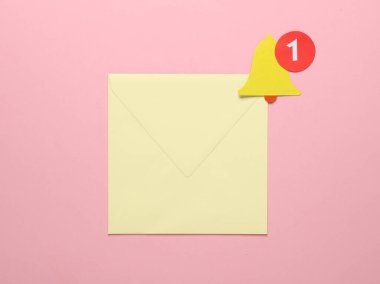 Zarf ve Kağıt, pembe arkaplanda uyarı çanı simgesini kesti