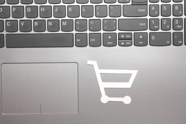 Klavyede kağıt kesiği olan bir alışveriş arabası simgesi. İnternetten alışveriş