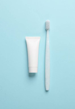 Mavi arka planda diş fırçası ve diş macunu tüpü. Model