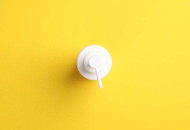 Sarı arka planda beyaz losyon kutusu. Üst görünüm