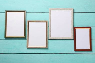 Mavi ahşap arkaplanda boş duvar çerçeveleri