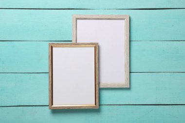 Mavi ahşap arkaplanda boş duvar çerçeveleri