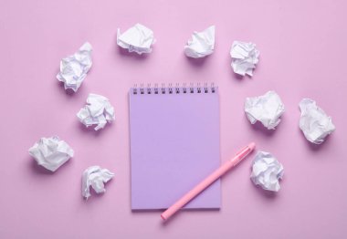 Pastel arka planda defter olan buruşmuş kağıt toplar. İş konsepti