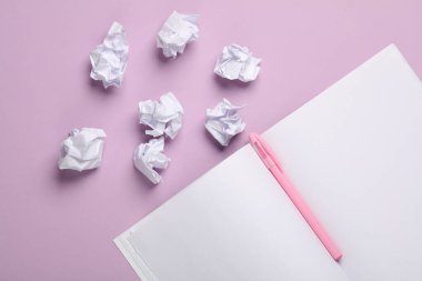 Buruşuk kağıt toplar ve pastel arka planda açık notebbok. Eğitim, İş Konsepti