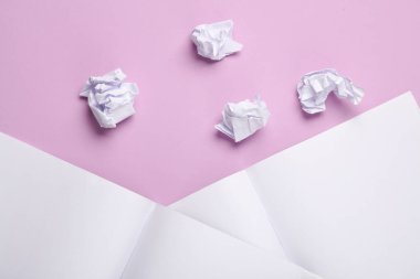 Buruşuk kağıt toplar ve pastel arka planda açık not defterleri. Eğitim, İş Konsepti