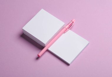 Pastel arka planda kalemli not kağıtları yığını