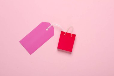 Minyatür alışveriş çantası ve pembe arka planı var. Kara Cuma, dünya alışveriş günü, indirim.