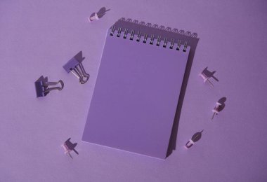 Kağıt ciltli ve iğneli mor not defteri. Minimalizm. Yaratıcı düzen. Eğitim, kırtasiye