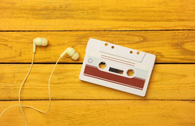 Sarı ahşap tahtalarda kulaklıklı Retro 80 'lerin ses kaseti. Üst görünüm