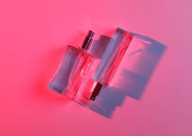 Kırmızı mavi ışıklı, gölge ve refleksli parfüm şişeleri. Güzellik ve moda natürmort