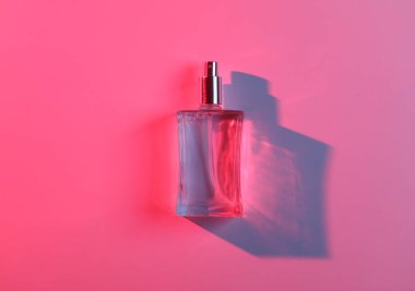 Kırmızı mavi ışıklı, gölge ve refleksli parfüm şişesi. Güzellik ve moda natürmort