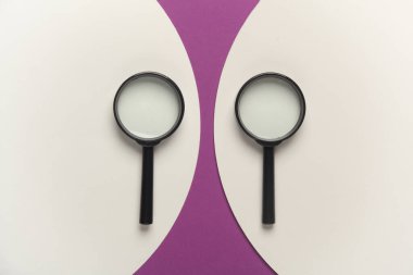 Mor arka planda büyüteç ve beyaz daireler. Üst görünüm