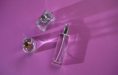 Mor arka planda cam parfüm şişeleri