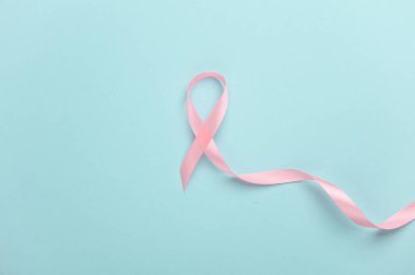 Pembe kurdele, mavi arka planda göğüs kanseri farkındalığı sembolü. Kadın Sağlığı