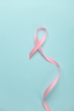 Pembe kurdele, mavi arka planda göğüs kanseri farkındalığı sembolü. Kadın Sağlığı