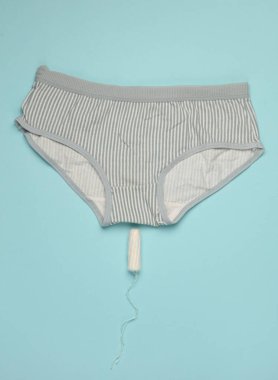 Mavi arka planda tampon olan külotlar. Kritik Kadın Günleri
