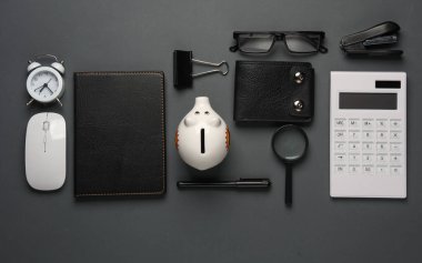 Koyu gri arka planda defter ve kırtasiye malzemeleri. İş konsepti. Yaratıcı düzen. Üst Manzara. Düz yatıyordu