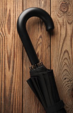 Ahşap arka planda siyah şemsiye kancası