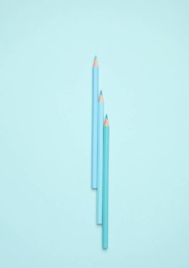 Mavi arkaplanda mavi tonda üç renkli kalem.