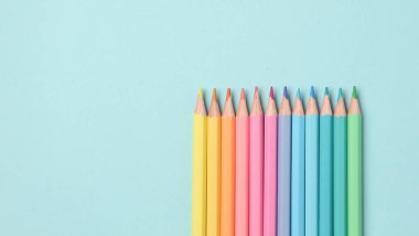 Mavi bir arka plan üzerinde renkli kalemler set