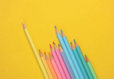 Sarı arkaplanda renkli kalemler.