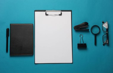 Mavi arka planda pano ve ofis kırtasiyesi. Düz yatıyordu